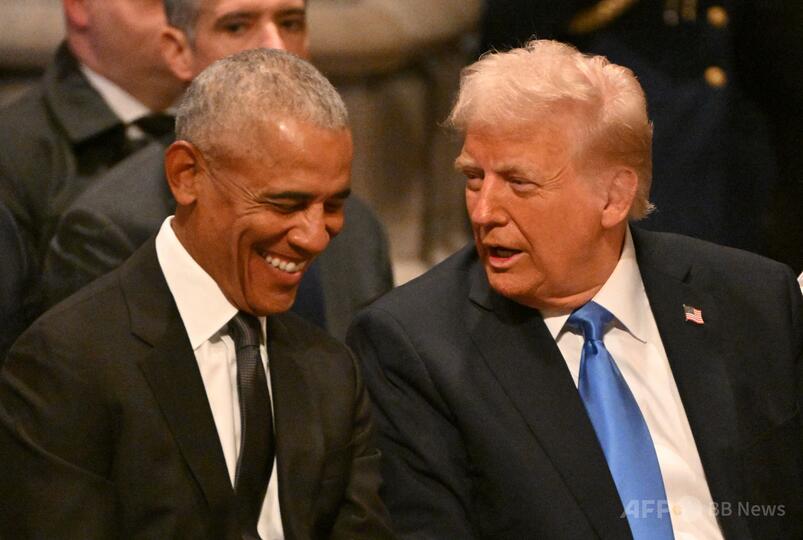 米首都のワシントン大聖堂で行われたジミー・カーター元米大統領の国葬で、ドナルド・トランプ大統領（右）と話すバラク・オバマ元大統領（2025年1月9日撮影）。(c)ROBERTO SCHMIDT/AFP
