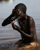2007年10月20日、ウガンダで、洗濯の際に水浴びをする女の子。(c)AFP/Roberto SCHMIDT