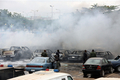 ナイジェリアの首都アブジャ（Abuja）の警察本部で、爆発の被害を受けた車を調べる警官（2011年6月16日撮影）。(c)AFP/SUNDAY AGHAEZE