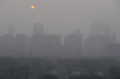 中国・北京（Beijing）で、スモッグで霞む中央商務区（Central Business District、CBD）の背後に登る朝日（2008年6月4日撮影）。(c)AFP/Frederic J. BROWN