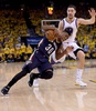 14-15NBAプレーオフ1回戦（7回戦制）、ゴールデンステイト・ウォリアーズ対ニューオーリンズ・ペリカンズ。ゴールデンステイト・ウォリアーズのクレイ・トンプソン（奥）のディフェンスをかわし、トラベリングを取られたニューオーリンズ・ペリカンズのノリス・コール（2015年4月20日撮影）。(c)AFP/Getty Images/Thearon W. Henderson