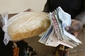 ジンバブエの首都ハラレ（Harare）で、パンを買うために何十枚ものジンバブエドル札を手にする客（2008年9月21日撮影）。(c)AFP/Desmond Kwande