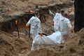 ウクライナ・イジューム近郊の森で見つかった遺体を搬送する科学捜査班（2022年9月16日撮影）。(c)SERGEY BOBOK / AFP