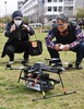 千葉市で、自律制御システム研究所が開発したドローンを見つめる住民たち（2016年4月11日撮影）。(c)AFP/TORU YAMANAKA