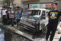 イラクの首都バグダッド（Baghdad）で起きた自動車爆弾攻撃の現場で、損傷した車の近くに集まる人びと（2013年5月30日撮影）。(c)AFP/AHMAD AL-RUBAYE
