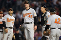 米大リーグ（MLB）で15日、アフリカ系米国人初の大リーガーとして活躍した故ジャッキー・ロビンソン（%%Jackie Robinson%%）氏の栄誉をたたえるジャッキー・ロビンソンデーを迎え、全試合で全選手、全コーチ陣、全審判員が同氏の永久欠番である背番号「42」を着用して試合に臨んだ。写真はテキサス・レンジャーズ（%%Texas Rangers%%）戦の4回で途中降板するボルチモア・オリオールズ（%%Baltimore Orioles%%）のマーク・ヘンドリクソン（%%Mark Hendrickson%%、中央）。（2009年4月15日撮影）（c）AFP/Getty Images/Ronald Martinez