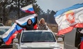 クリミア半島の港湾都市セバストポリで、ロシアによるクリミア併合5周年を祝ってロシア国旗を振る女性ら（2019年3月16日撮影）。(c)AFP