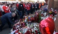 リバプール（Liverpool FC）の本拠地アンフィールド（Anfield）の外に設けられた祈念碑の前に花を手向ける人々（2014年4月15日撮影）。(c)AFP/PAUL ELLIS
