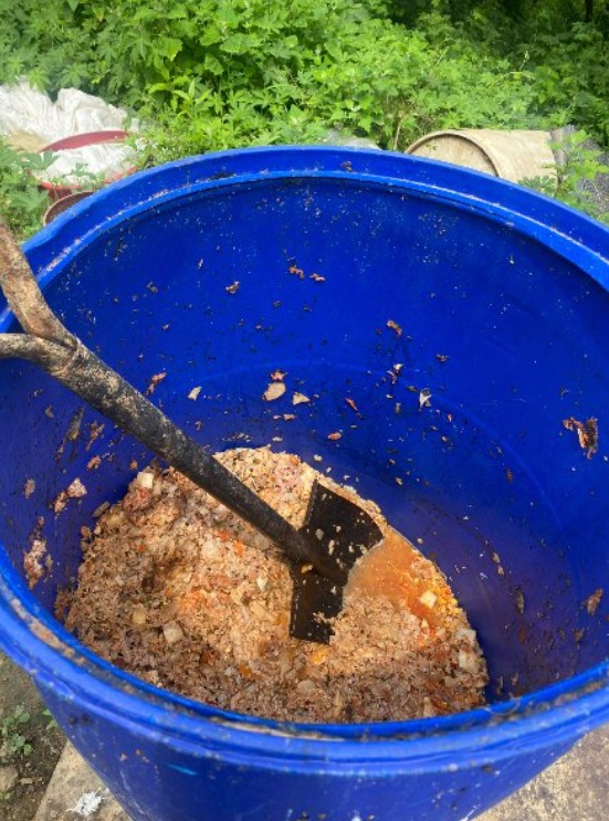 檻の近くに置いてあった飼料桶。最初から大きな桶に入れ、シャベルですくっているようだ。主人は記者が訪問すると蓋を閉めた(c)MONEYTODAY