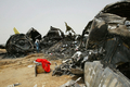 スーダンの首都ハルツーム（Khartoum）の空港で、前夜にスーダン航空（Sudan Airways）の旅客機が着陸時に炎上した現場を歩く警察官（2008年6月11日撮影）。(c)AFP/ISAM AL-HAJ