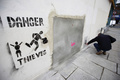 英国のグラフィティ（落書き）アーティスト、バンクシー（Banksy）氏がロンドン（London）市内の壁に描いた絵が、米国で競売にかけられることが分かったが、怒った住民たちの抗議によって競売への出品は中止されたと、地元自治体が24日、明らかにした。

写真は、バンクシー（Banksy）氏の壁画が持ち去られた跡の壁に「危険！泥棒出没」と新たに書かれた絵（2013年2月23日撮影）。(c)AFP/JUSTIN TALLIS