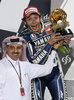 世界ロードレース選手権（WGP 2013）開幕戦カタールGP、MotoGPクラス決勝。2位に入り、表彰台でトロフィーを掲げるヤマハ・ファクトリー（Yamaha Factory）のバレンティーノ・ロッシ（Valentino Rossi、2013年4月7日撮影）。(c)AFP/AL-WATAN DOHA/KARIM JAAFAR