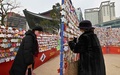 韓国ソウル中心部の曹渓寺（チョゲサ）で、新年の願い事を書いたカードを掛ける人々（2022年12月31日撮影）。(c)Jung Yeon-je / AFP