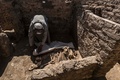 エジプト・ルクソール近郊で発見された古代都市遺構で、動物の骨にカバーをかける作業員（2021年4月10日撮影）。(c)Khaled DESOUKI / AFP