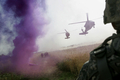 イラク・バグダッド（Baghdad）東部郊外のAl-Rudwaniyahで、紫色の煙が立ち上る中、ブラックホーク（Blackhawk）ヘリコプターの到着を待つ米兵ら（2008年5月2日撮影）。(c)AFP/MAURICIO LIMA