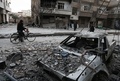 シリアの首都ダマスカス近郊の反体制派支配地区、東グータで、がれきのそばを歩く人（2018年2月25日撮影）。(c)AFP PHOTO / ABDULMONAM EASSA
