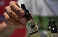 コロンビア・ボゴタで、医療用に栽培された大麻の関連商品の展示会に出品されている大麻の商品を見せる男性（2015年12月22日撮影）。(c)AFP/GUILLERMO LEGARIA