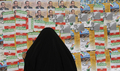 2008年3月11日、イランの首都テヘラン（Teheran）で、総選挙ポスターを見る女性。(c)AFP/BEHROUZ MEHRI