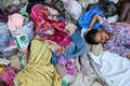 インドネシア・アチェ州サバン島の浜辺で休む、漂着したばかりのロヒンギャ難民ら（2023年12月2日撮影）。(c)CHAIDEER MAHYUDDIN / AFP