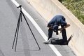 オーストラリア・メルボルン郊外で、高速道路に転がった事故機の部品を撮影する警官（2017年2月21日撮影）。(c)AFP/Mal Fairclough