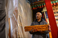 調査する古書を運ぶノルブリンカ管理処古文書調査チームの久米次成（ＧｙｕｍｅｙＴｓｕｌｔｒｉｍ）さん（2023年4月19日撮影）。(c)Xinhua News