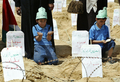 パレスチナ自治区ガザ地区（Gaza Strip）南部のエジプトと境界を接するラファ（Rafah）で、イスラエルのガザ地区封鎖に抗議して作った偽物の墓のそばに座るパレスチナ人の子ども（2008年4月23日撮影）。(c)AFP/SAID KHATIB