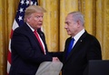米首都ワシントンのホワイトハウスで、中東和平案を発表する記者会見を開き、イスラエルのベンヤミン・ネタニヤフ首相（右）と握手するドナルド・トランプ米大統領（2020年1月28日撮影）。(c)MANDEL NGAN / AFP