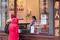 英ロンドンの中華街にある食品店で、マスクを着けて接客する従業員（2020年2月4日撮影）。(c)JUSTIN TALLIS / AFP