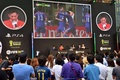 都内で行われた家庭用ゲーム機「プレイステーション4（PlayStation 4、PS4）」用サッカーゲーム「FIFA 14  2014 FIFA World Cup Brazil  Limited Pack」の発売イベントで、大型スクリーンに映ったゲーム画面を眺めるサッカーファンら（2014年6月4日撮影）。(c)AFP/Yoshikazu TSUNO