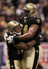 09NFLプレーオフ、ナショナル・カンファレンス（NFC）決勝、ニューオーリンズ・セインツ（%%New Orleans Saints%%）対ミネソタ・バイキングス（%%Minnesota Vikings%%）。試合はセインツが31-28で勝利し、チーム創設以来初のスーパーボウル進出を決めた。写真は第1クォーターに38ヤードのタッチダウンパスをレシーブし、ジャーモン・バシュロッド（%%Jermon Bushrod%%、右）とともに歓喜するセインツのピエール・トーマス（%%Pierre Thomas%%）。（2010年1月24日撮影）(c)AFP/Getty Images/Jed Jacobsohn
