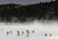 写真はアイスランドの首都レイキャビク（Reykjavik）郊外にある温泉｢ブルーラグーン（Blue Lagoon）｣を楽しむ観光客。ブルーラグーンは水の色が青と緑であることから、この名で呼ばれている。健康効果もうたわれている（2009年4月26日撮影）。(c)AFP/OLIVIER MORIN