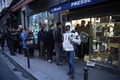 フランス・パリ（Paris）市内にある新聞の販売店で、風刺週刊紙シャルリー・エブド（Charlie Hebdo）の本社襲撃事件後初となる最新号の発売に合わせて列を作る客（2015年1月14日撮影）。(c)AFP/MARTIN BUREAU