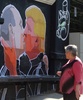 リトアニアの首都ビリニュスで、キスをするドナルド・トランプ氏とウラジーミル・プーチン大統領が描かれた壁画を立ち止まって見る通勤者（2016年5月13日撮影）。(c)AFP/Petras Malukas