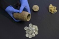 ユダヤ砂漠にあるムラバット洞窟の発掘現場で出土した筒と、その中に入っていた15枚の銀貨（2022年12月13日撮影）。(c)MENAHEM KAHANA / AFP