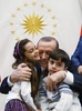 トルコの首都アンカラの大統領府で、レジェプ・タイップ・エルドアン大統領（中央）に抱き締められるバナ・アベドさん（左）と弟。トルコ大統領府提供（2016年12月21日撮影・公開）。(c)AFP/Turkish Presidential Press Office/KAYHAN OZER