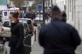 銃撃のあった仏パリ（Paris）にある風刺週刊紙シャルリー・エブド（Charlie Hebdo）の本社前に集まる警察官と消防隊員（2015年1月7日撮影）。(c)AFP/KENZO TRIBOUILLARD
