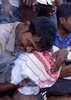 インド北東部アッサム州ソニトプル地区で、魔術信仰者とされる男に斬首されて殺された5歳男児の遺体を抱いて嘆く親族の男性（2015年5月29日撮影）。(c)AFP