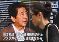 北朝鮮による飛翔体発射について記者会見を行う安倍晋三首相を映したテレビの前を通り過ぎる歩行者。都内にて（2019年8月16日撮影）。(c)Kazuhiro NOGI / AFP