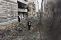 シリア・アレッポ東部で、荒廃した地区を走行する列車に手を振る人たち（2017年1月25日撮影）。(c)AFP/George OURFALIAN