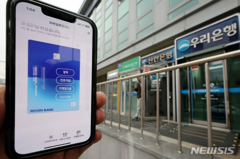 ソウル市内のATMブースとモバイルキャッシュカードアプリの画面(c)NEWSIS