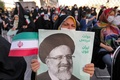 イランの首都テヘランのイマーム・フセイン広場で、大統領選で勝利したエブラヒム・ライシ師のポスターを手にする女性。ポスターにはペルシャ語で「国民の政府、強いイラン」と書かれている（2021年6月19日撮影）。(c)ATTA KENARE / AFP