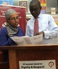 ケニア・ナイロビ（Nairobi）で、16歳の少女を集団レイプした男3人に罰則として「草刈り」が言い渡されたことに対する抗議の請願書を読む、アフリカの人権団体FEMNETの広報責任者、ネビラ・アブドルメリク（Nebila Abdulmelik）氏（左、2013年10月28日撮影）。(c)AFP/SIMON MAINA