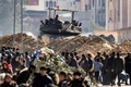 パレスチナ自治区ガザ地区南部に逃れてきた人々と、配備されたイスラエル軍の戦車（2024年1月30日撮影）。(c)Mahmud Hams / AFP