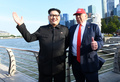 シンガポールのマーライオン公園で、ドナルド・トランプ米大統領のそっくりさんと一緒にポーズをとる金正恩（キム・ジョンウン）朝鮮労働党委員長のそっくりさんのハワードXさん（2018年6月8日撮影）。(c)AFP/Roslan RAHMAN