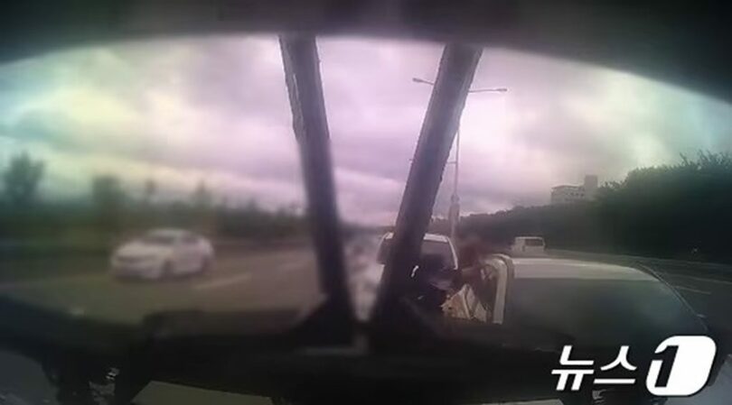 車の運転手を救うため、助手席の窓を割っている警察官＝警察署提供(c)news1