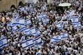 中東エルサレムで、イスラエル国旗を掲げて「嘆きの壁」前に集まったユダヤ人デモ隊（2022年5月29日撮影）。(c)GIL COHEN-MAGEN / AFP