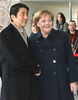 写真はベルリンで同日、公式歓迎式典で握手を交わす安倍首相とメルケル首相。(c)AFP/JOHN MACDOUGALL