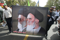イランの首都テヘラン（Tehran）で、最高指導者アリ・ハメネイ（Ali Khamenei）師（左）とイラン革命の指導者、故ホメイニ（Ruhollah Khomeini）師の肖像を掲げて行進する人びと（2009年9月18日撮影）。(c)AFP/ATTA KENARE