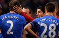 12-13イングランド・プレミアリーグ第34節、リバプール（Liverpool FC）対チェルシー（Chelsea）。かみつかれたとケビン・フレンド（Kevin Friend）主審（中央）に主張するチェルシーのブラニスラフ・イヴァノヴィッチ（Branislav Ivanovic、左）と、その横で笑顔を見せるリバプールのルイス・スアレス（Luis Suarez、右から2人目、2013年4月21日撮影）。(c)AFP/ANDREW YATES