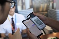 電源不要型電子手荷物タグの操作を説明する職員（2019年7月30日撮影）。(c)CNS/殷立勤